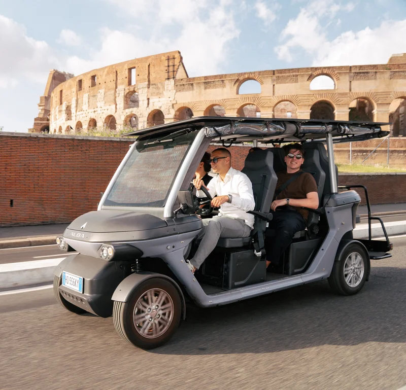 Golf cart con Andrea alla guida davanti al Colosseo